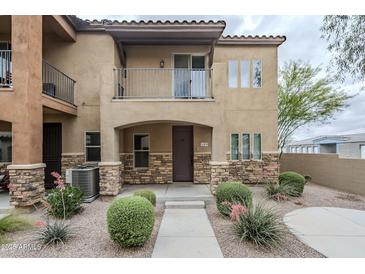 Inviting townhome featuring a covered entry, balcony, stone accents, and xeriscaped front yard at 2821 S Skyline Dr # 149, Mesa, AZ 85212