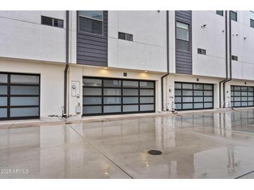 Modern townhome exterior featuring glass garage doors and neutral color palette at 325 E Coronado Rd # 8, Phoenix, AZ 85004