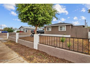 Cozy home featuring a secure front yard with a classic decorative fence at 5519 W Campbell Ave, Phoenix, AZ 85031