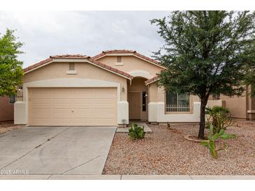 Charming single-story home with a two-car garage and low maintenance desert landscaping at 9319 W Crown King Rd, Tolleson, AZ 85353