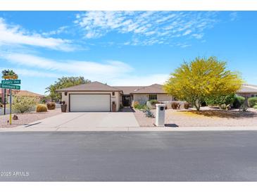 Charming single-story home featuring a well-manicured front yard and a two-car garage at 9621 E Calgary Ave, Sun Lakes, AZ 85248