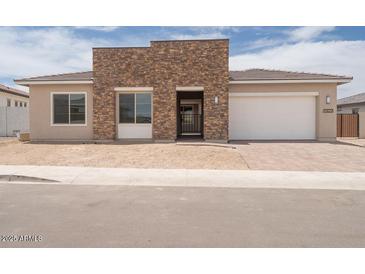 Charming single-story home featuring a stacked stone entry and a two car garage at 10022 S 37Th Ave, Laveen, AZ 85339