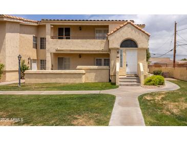 Charming two-story condo featuring stucco siding, a red tile roof and well-maintained front lawn at 1333 E Morten Ave # 230, Phoenix, AZ 85020