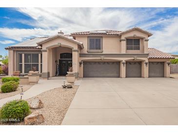 Charming two-story home with a three-car garage, covered entry, tile roof, and desert landscaping at 24916 N 80Th Ln, Peoria, AZ 85383