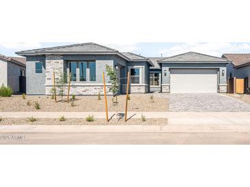 Beautiful single-story home with a gray stucco exterior, white brick accents, and a two-car garage at 26139 S 225Th Way, Queen Creek, AZ 85142