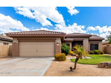 Charming single-story home with a well-maintained front yard, a two car garage and desert landscaping at 2685 N 132Nd Dr, Goodyear, AZ 85395