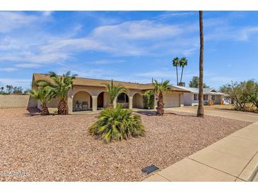 Charming home featuring arched entryway, mature palm trees, and low-maintenance desert landscaping at 3021 S Evergreen Rd, Tempe, AZ 85282