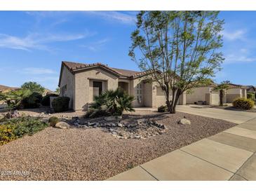 Charming single-story home with desert landscaping, a beautiful tree, and a two car garage at 4293 E Sourwood Dr, Gilbert, AZ 85298
