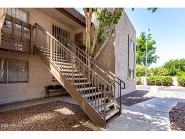 Apartment staircase with well maintained landscaping and neutral color scheme at 520 N Stapley Dr # 253, Mesa, AZ 85203