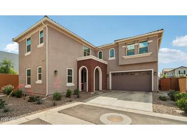 Charming two-story home featuring a brick arched entryway and attached two-car garage at 670 S Beebe St, Gilbert, AZ 85296