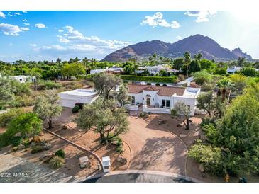 Stunning single-story home featuring a red tile roof, circular driveway, and mature landscaping with a mountain view at 6701 E San Miguel Ave, Paradise Valley, AZ 85253