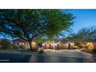 Charming home with a paver driveway, three-car garage and stone accents, all set beneath a twilight sky at 7130 E Saddleback St # 58, Mesa, AZ 85207
