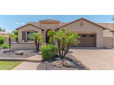 Beautiful single-story home with lush landscaping, a charming entrance, and a paved driveway at 15353 W Cheery Lynn Rd, Goodyear, AZ 85395