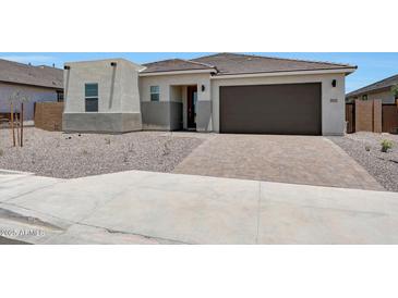 Charming single-story home with a desert landscape, brick driveway, and a two car garage at 18522 W Mohave St, Goodyear, AZ 85338