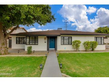 Charming single-story home with a well-manicured lawn, blue front door, and a welcoming walkway at 2501 E Campbell Ave, Phoenix, AZ 85016