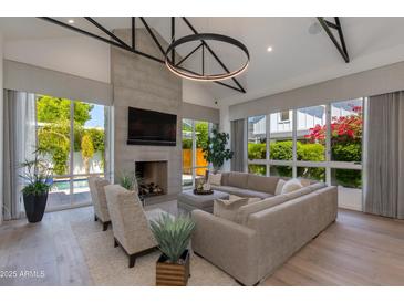 Bright living room features a concrete fireplace, hardwood floors, and large windows with views of the pool at 4416 N 37Th Way, Phoenix, AZ 85018