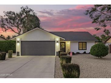 Charming home with a two-car garage, manicured landscaping, and inviting curb appeal at twilight at 5238 E Beck Ln, Scottsdale, AZ 85254