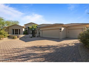 Charming single-story home featuring a three-car garage, beautiful stonework, and a manicured desert landscape at 6621 E Oberlin Way, Scottsdale, AZ 85266