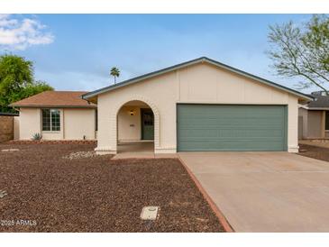 Charming single-story home featuring an arched entryway, a two-car garage, and desert landscaping at 2006 N Arrowhead Dr, Chandler, AZ 85224