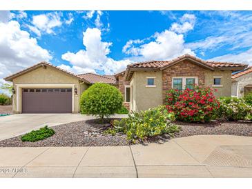 Charming home with well-manicured landscaping, stone accents, and a spacious two-car garage at 20642 N 268Th Dr, Buckeye, AZ 85396