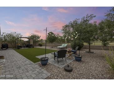 Expansive backyard featuring a patio, lush trees, and a charming pergola for outdoor relaxation at 35773 N Loemann Dr, San Tan Valley, AZ 85143