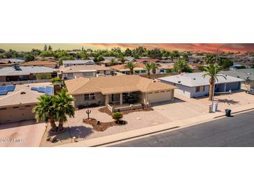 Charming single-story home with desert landscaping, lush palm trees, and attached two-car garage at 4655 E Farmdale Ave, Mesa, AZ 85206