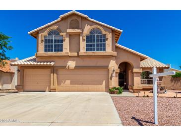 Charming two-story home featuring a three-car garage and decorative architectural details at 5216 W Oraibi Dr, Glendale, AZ 85308
