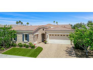 Beautiful single-story home featuring a three-car garage, stone accents, manicured landscaping, and tile roof at 5542 E Alan Ln, Paradise Valley, AZ 85253