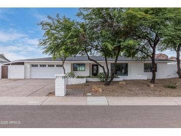 Charming single-story home with a white brick exterior, desert landscaping, and a spacious driveway at 6019 E Windsor Ave, Scottsdale, AZ 85257