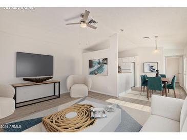 Bright living room with ceiling fan, open floor plan, and neutral decor at 13521 E Butler St, Chandler, AZ 85225