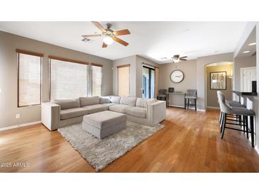 Inviting living room features a plush sectional sofa, ottoman, and hardwood floors at 16600 N Thompson Peak Pkwy # 2006, Scottsdale, AZ 85260