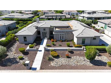 A modern home boasts a beautifully landscaped front yard with pavers leading to the front door at 2735 E King Bird Dr, Gilbert, AZ 85297