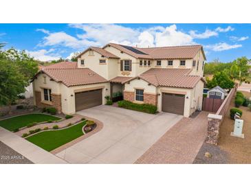 Expansive two-story home featuring a three-car garage, meticulously landscaped yard, and a classic tile roof design at 2851 E Alexander Ct, Gilbert, AZ 85298