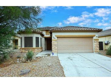 Charming single-story home featuring a tile roof, stone accents, and a well-maintained front yard at 36950 W Mondragone Ln, Maricopa, AZ 85138