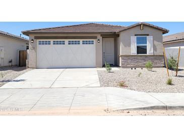 Charming single-story home features a two-car garage and neutral-toned exterior with rock landscaping at 37125 W Prado St, Maricopa, AZ 85138
