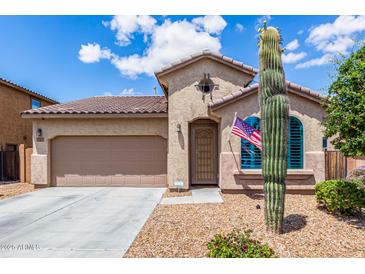 Charming stucco home featuring a desert landscape, attached two-car garage, and a welcoming front entrance at 41342 W Elm Dr, Maricopa, AZ 85138