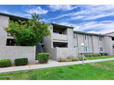 Inviting exterior view of apartment building with well-maintained landscaping and a blue cloudy sky at 623 W Guadalupe Rd # 279, Mesa, AZ 85210