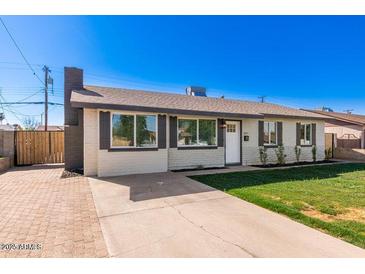 Charming single-story home featuring a well-maintained lawn, brick accents, and a welcoming front entrance at 6821 W Mariposa St, Phoenix, AZ 85033