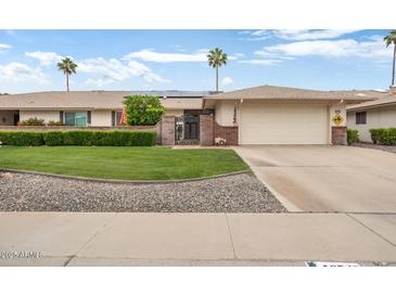 Charming single-story home featuring a well-manicured lawn and a two car garage at 12542 W Parkwood Dr, Sun City West, AZ 85375