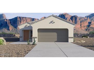Charming single-story home featuring a spacious two-car garage and desert landscaping against a mountain backdrop at 1811 W Solstice Ave, Apache Junction, AZ 85120