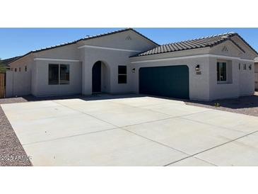 Charming single-story home with a dark-green garage door and a spacious driveway at 2512 N Pony Ln, Casa Grande, AZ 85122