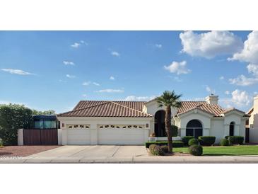 Charming single-story home featuring a manicured lawn and attached two car garage at 7648 W Mauna Loa Ln, Peoria, AZ 85381