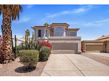 Beautiful two-story home featuring a Spanish tile roof, desert landscaping, and a two-car garage at 11049 N 111Th Way, Scottsdale, AZ 85259