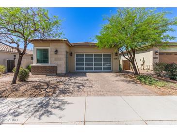 Charming single-story home featuring a brick driveway and desert landscaping at 12083 W Peak View Rd, Peoria, AZ 85383