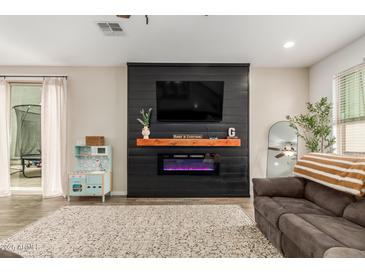 Comfortable living room featuring a modern electric fireplace and a cozy seating area at 13380 N 148Th Ave, Surprise, AZ 85379