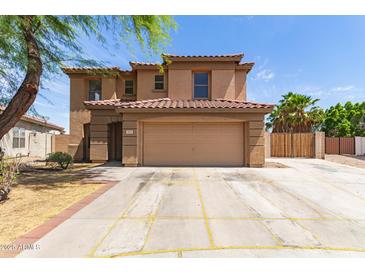 Charming two-story home featuring a red tile roof, tan stucco, and a spacious two-car garage at 304 E Beth Dr, Phoenix, AZ 85042