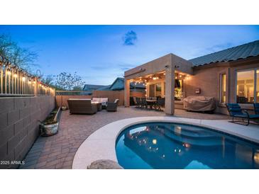 Inviting backyard featuring a covered patio, outdoor kitchen, cozy seating around a fire pit and a sparkling pool at 3521 N Barron --, Mesa, AZ 85207