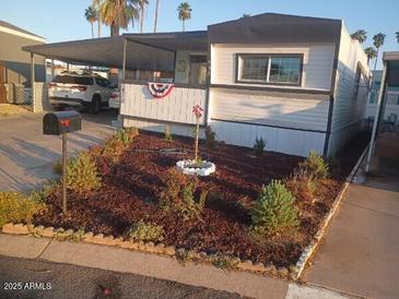 Charming single story home featuring manicured flower beds and a covered parking area at 701 S Dobson Rd # 438, Mesa, AZ 85202