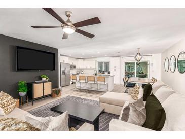 Open-concept living room flows into the kitchen with stainless steel appliances and a kitchen island with bar seating at 8437 E Bonnie Rose Ave, Scottsdale, AZ 85250