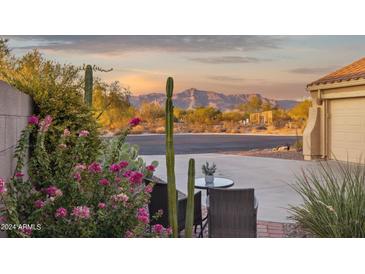 Inviting exterior view showcasing desert landscaping, colorful flowering shrubs, and peaceful mountain views at 10109 E Trailhead Ct, Gold Canyon, AZ 85118